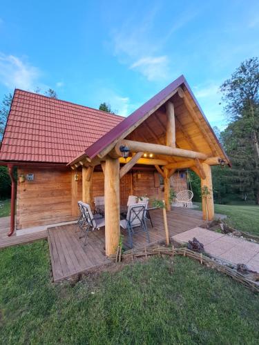 Cabaña de madera con terraza y sillas en Guest house Mihovil, en Slunj