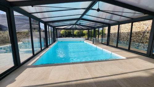 a swimming pool in a glass house with a view at Villa Marie in Saint-Igneuc