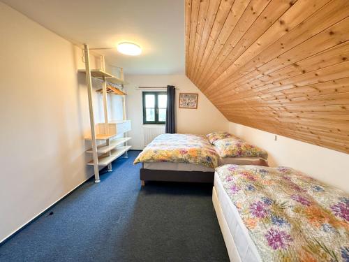 1 Schlafzimmer mit 2 Betten und Holzdecke in der Unterkunft Třicítka na Šťastném kopci in Černý Důl