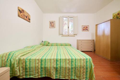 a bedroom with a bed and a dresser and a window at Mare Etrusco 2 in Populonia