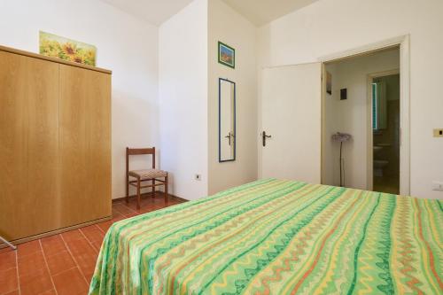 a bedroom with a bed and a cabinet and a chair at Mare Etrusco 2 in Populonia