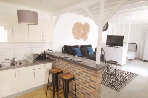 une cuisine avec un comptoir avec des tabourets et un canapé dans l'établissement Grand studio proche Paris avec terrasse, à Saint-Maurice