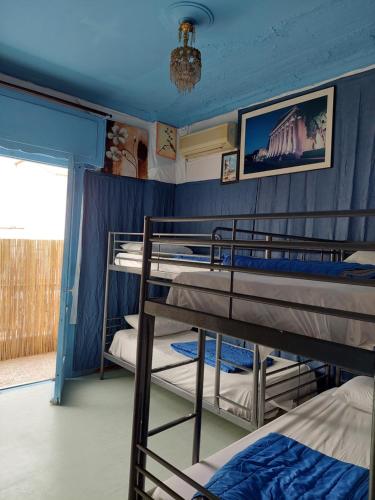 雅典的住宿－ACROPOLIS ViEW MIXED DORMITORIES 1 MINUTE BY THISSIO METRO STOP，蓝色墙壁的客房内设有两张双层床。