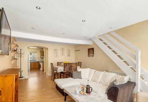 a living room with a white couch and a staircase at King's Apartment in Clifden