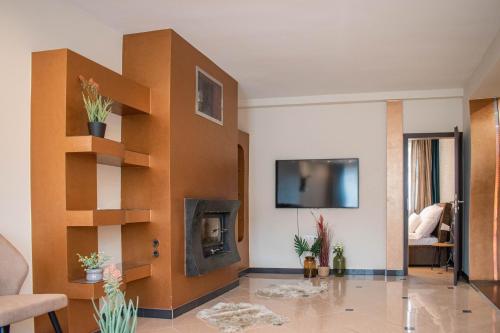 Elle comprend un salon avec une cheminée et une télévision murale. dans l'établissement Garden Apartments, à Szeged