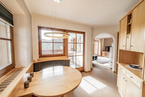 una cucina con tavolo in legno e una grande finestra di Apartment Misalt a Castelrotto