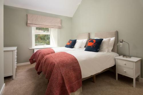 een slaapkamer met een bed met een rode deken erop bij Lyme Grass in Bamburgh