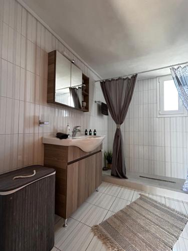 Dim Domus _ Apolakkia, South Rhodes في Apolakkiá: حمام مع حوض وحوض استحمام ودش