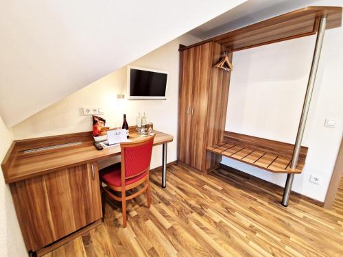 a hotel room with a desk and a window at Landgasthof Rebstock in Ottenhöfen