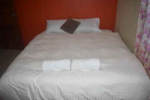 białe łóżko z 3 składanymi ręcznikami w obiekcie Serenity Homes w mieście Sigatoka