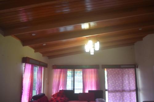 a living room with windows with pink curtains at Serenity Homes in Sigatoka