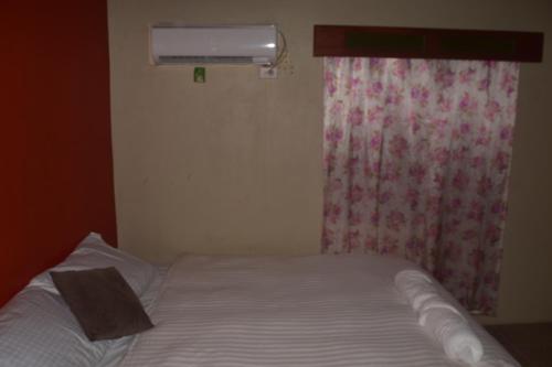 sypialnia z łóżkiem i oknem z kocem w obiekcie Serenity Homes w mieście Sigatoka