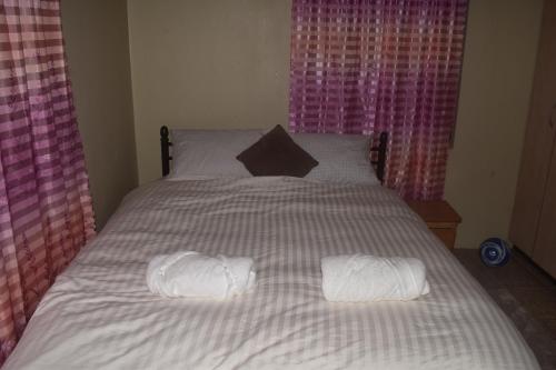 łóżko z dwoma białymi ręcznikami na górze w obiekcie Serenity Homes w mieście Sigatoka