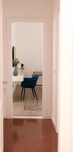 a hallway with a blue chair and a desk at Ottanta5 Private Rooms in Messina