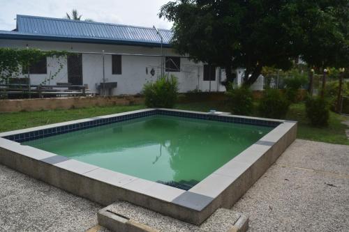 a swimming pool in front of a house at Serenity Homes in Sigatoka