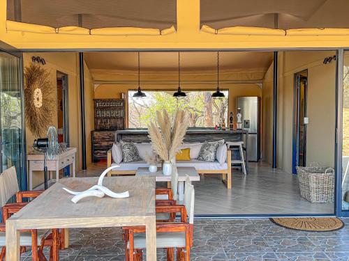 patio ze stołem, krzesłami i kanapą w obiekcie African Dream Tour w mieście Hoedspruit