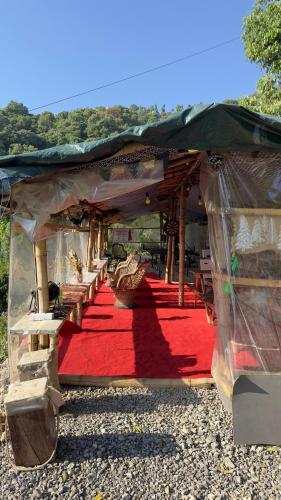 a tent with a red carpet and a red rug at Ananta Prana in Mussoorie