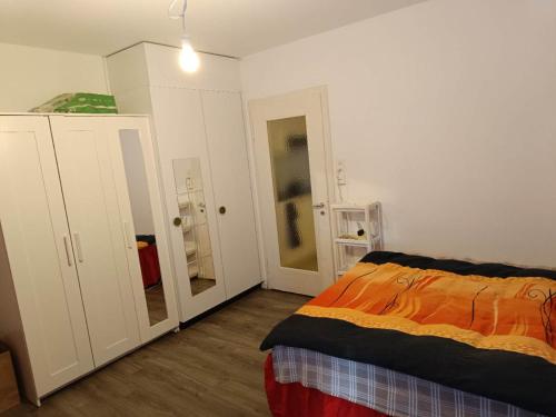 1 dormitorio con 1 cama con manta naranja en Serviced Studio St Gallen City L51, en St. Gallen