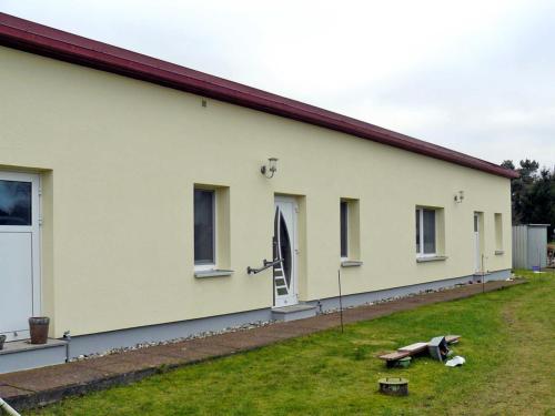 a white building with a grass yard next to it at Ferienwohnung Haus Möwe in Freest