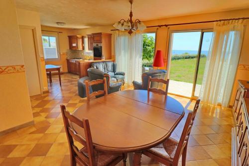 a dining room and living room with a table and chairs at 605 VIlla ocean Atlantique au bout du jardin in Audierne