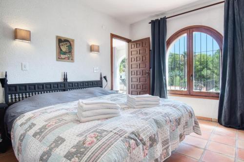 - une chambre avec un lit et une grande fenêtre dans l'établissement Casa Tao, à Benissa