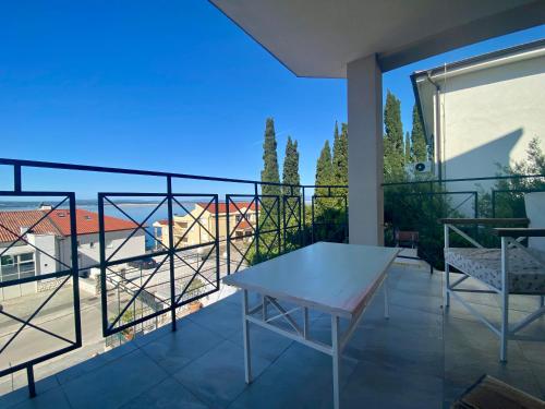 a balcony with a table and a view of a building at Rooms Villa Harmonie - Adults Only +14 in Crikvenica