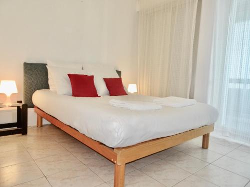 - un grand lit blanc avec des oreillers rouges dans l'établissement PGH N29-à 50m de la Plage, Vue mer, Parking Privé, à La Grande Motte