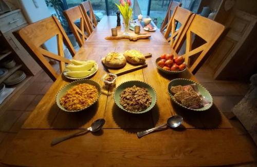 a wooden table topped with bowls of food and spoons at Bed & Breakfast - Shanakeever Farm in Clifden