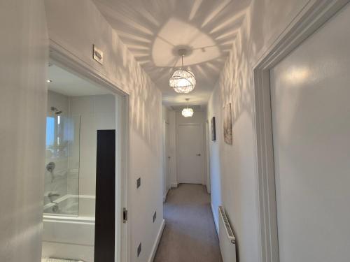 a hallway with a bathroom with a tub and a ceiling at Room in a pristine 4 bed home in Broomfield in Chelmsford