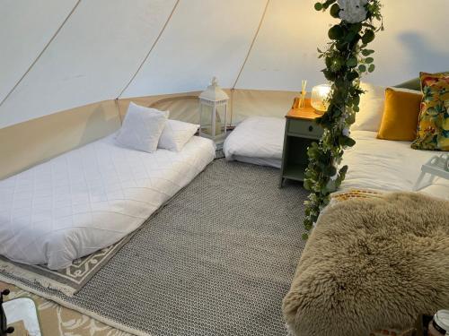 um quarto com duas camas numa tenda em Top pen y parc farm bell tent em Halkyn