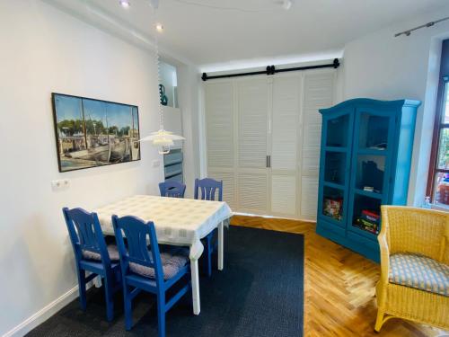 ein Esszimmer mit einem Tisch und blauen Stühlen in der Unterkunft Strand 2 in Laboe