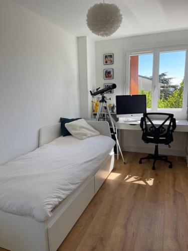 une chambre avec un lit et un bureau avec un ordinateur dans l'établissement Bel appart proche Paris, 3 chambres, Balcon & Parc, à Suresnes