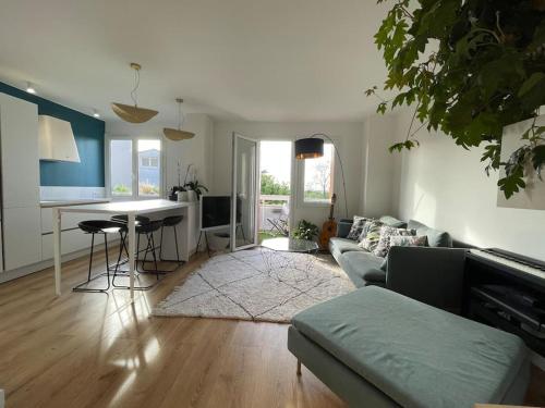 un salon avec un canapé et une table dans l'établissement Bel appart proche Paris, 3 chambres, Balcon & Parc, à Suresnes