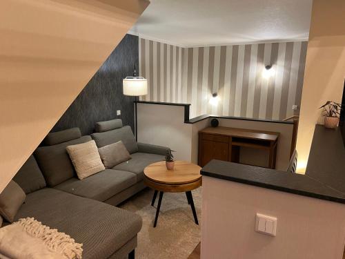 a living room with a couch and a table at Ferienwohnung Kempkens -Hochwertig & modern in Straelen