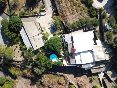 Cette chambre offre une vue sur une maison dotée d'une piscine et d'arbres. dans l'établissement I Dammusi di Punta Karace, à Tracino