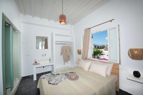 ein Schlafzimmer mit einem Bett mit Hut darauf in der Unterkunft Boutique di Vito in Mykonos Stadt
