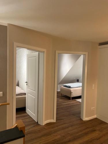 a room with two beds and a room with two doors at Ferienwohnung Kempkens -Hochwertig & modern in Straelen