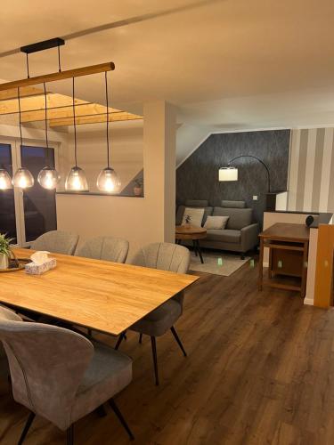a dining room and living room with a table and chairs at Ferienwohnung Kempkens -Hochwertig & modern in Straelen