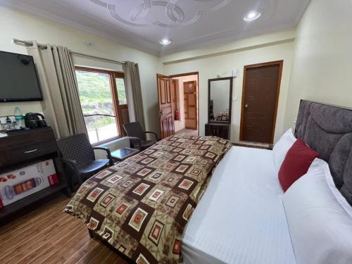 a bedroom with a bed and a television in it at Hill Veda Homestay in Kanatal