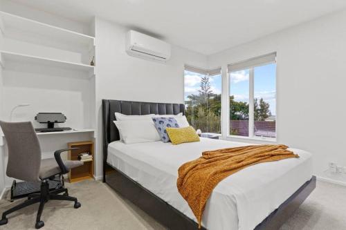 a bedroom with a bed and a desk and a window at Entire home in Central Auckland in Auckland