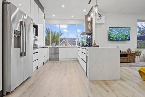 a kitchen with white cabinets and a large window at Entire home in Central Auckland in Auckland