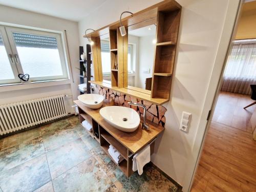 a bathroom with two sinks and a mirror at Landgasthof Rebstock in Ottenhöfen