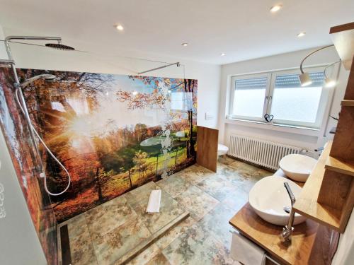 a bathroom with two toilets and a shower with a painting at Landgasthof Rebstock in Ottenhöfen
