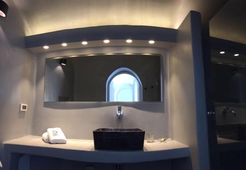 a bathroom with a sink and a mirror at Altana Cliffside Villas in Imerovigli