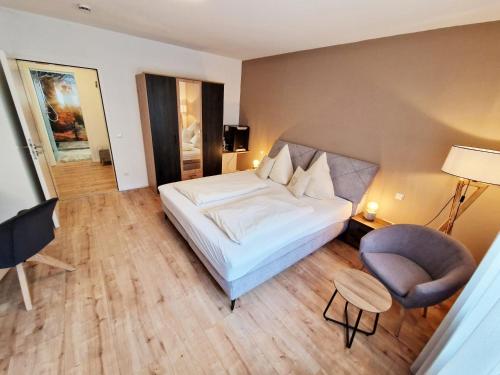 a hotel room with a bed and a chair at Landgasthof Rebstock in Ottenhöfen