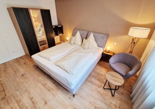 a hotel room with a bed and a chair at Landgasthof Rebstock in Ottenhöfen