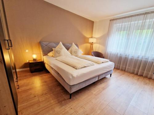 a bedroom with a bed with white sheets and a window at Landgasthof Rebstock in Ottenhöfen