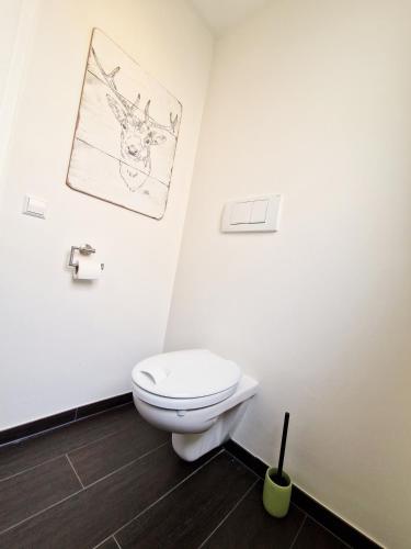 a bathroom with a toilet and a drawing on the wall at Landgasthof Rebstock in Ottenhöfen