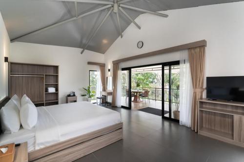 a large bedroom with a large bed and a television at Pelangi Park Hotel & Resort in Pasirkuda