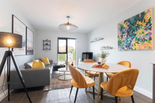 a living room with a table and chairs and a couch at Elliot Oliver - Stylish 2 Bedroom Apartment With Parking In The Docks in Gloucester